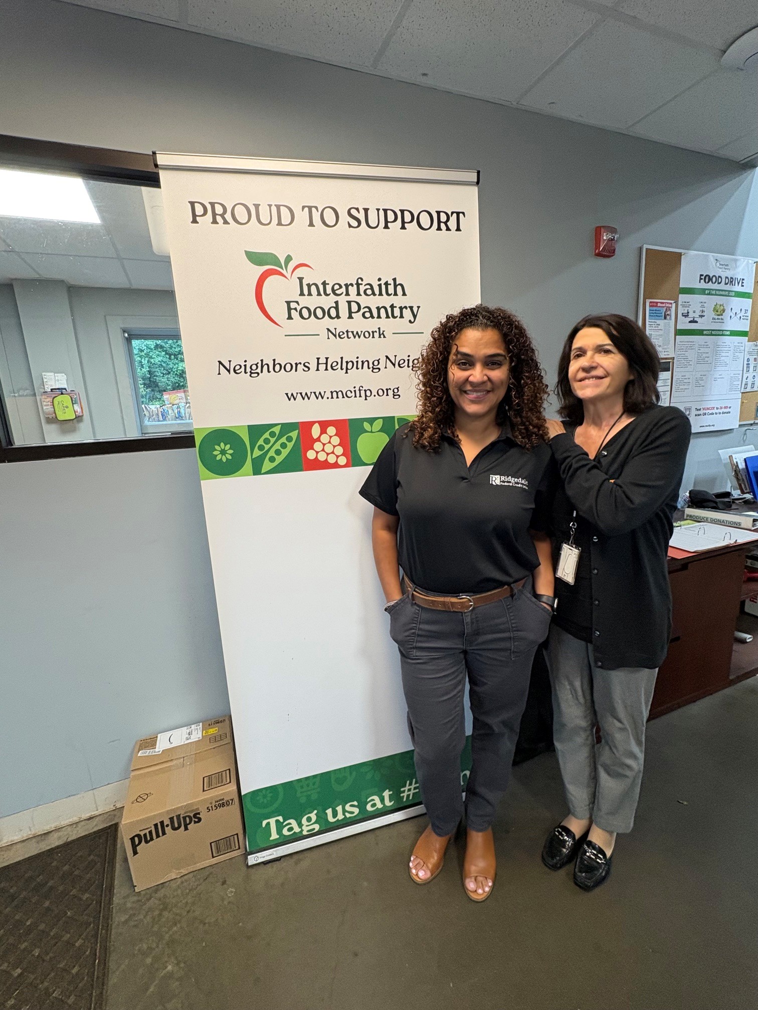 Ridgedale team members standing at the food pantry sign