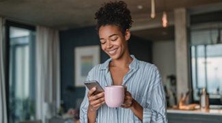 Women with coffee smiling as she looks at her phone