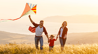mom, dad, and child flying a kite